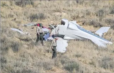  ?? Robert Gauthier Los Angeles Times ?? SHERIFF’S DEPUTIES inspect the site of a plane crash Sunday that killed pilot Thomas Hastings, 65, his daughter Amber Hill, 27; her husband, Jacob Hill, 25; and her daughter, Madison Hastings Saxelby, 9.