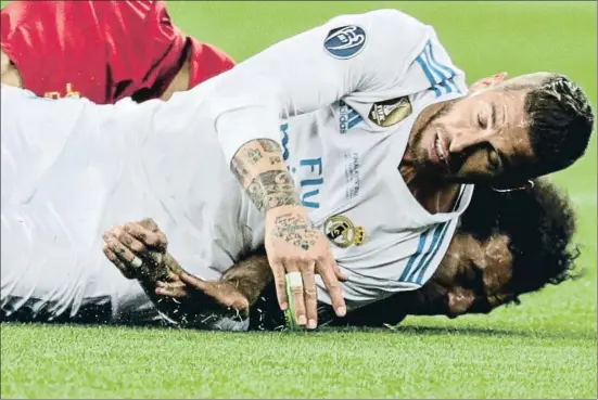  ?? ARMANDO BABANI / EFE ?? Sergio Ramos cae sobre Salah atrapando entre su cuerpo y el suelo el brazo del futbolista egipcio
