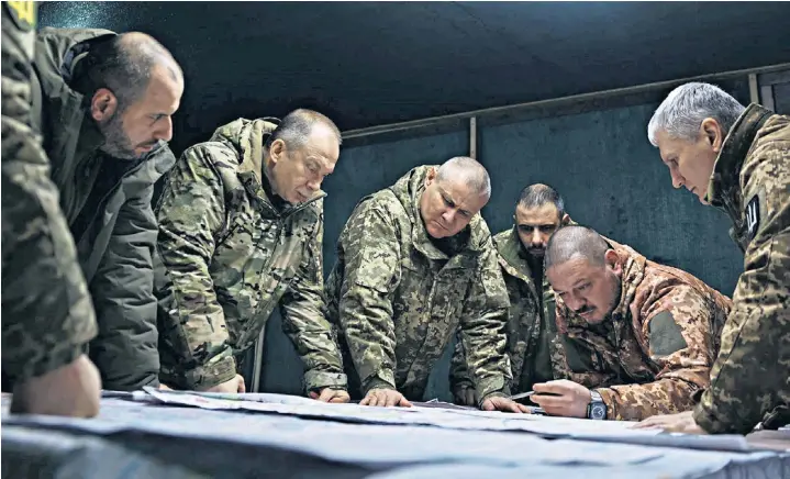  ?? ?? Col Gen Oleksandr Syrskyi, second from left, the newly appointed commander-in-chief of the Ukrainian armed forces, at a forward command post. He said: ‘The objective of our defence operation is to exhaust the enemy’s forces, inflict maximum losses on him’