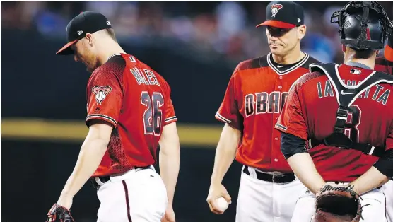  ?? ROSS D. FRANKLIN/THE ASSOCIATED PRESS ?? Arizona manager Torey Lovullo, centre, has brought an innovative approach to the way he uses his bullpen. The result has been a competitiv­e team.