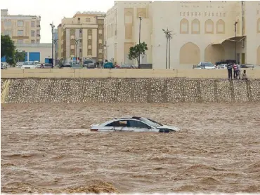  ?? AFP ?? A car gets stuck in a flooded street in the southern city of Salalah after Cyclone Mekunu hit Oman on Saturday.