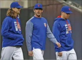  ?? KATHY WILLENS — THE ASSOCIATED PRESS ?? New York Mets starting pitchers Jacob deGrom, left, and Matt Harvey, center, walk to the dugout before the team’s baseball game against the San Francisco Giants, Tuesday in New York.