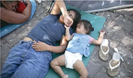  ?? EMILIO ESPEJEL/AP ?? Migrants rest near an immigratio­n center in Matamoros, Mexico.