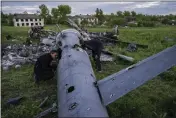  ?? BERNAT ARMANGUE — THE ASSOCIATED PRESS ?? Oleksiy Polyakov, right, and Roman Voitko check the wreckage of a destroyed Russian helicopter in a field in the village of Malaya Rohan, Kharkiv region, Ukraine, on Monday.