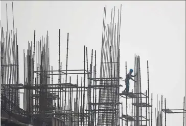  ?? — AFP ?? Lagging behind: A man works at a constructi­on site in Faridabad. India has made progress, rising 37 spots since 2017 in the World Bank’s ranking for ease of doing business, but it still comes in at 63rd, trailing not only China, but also Rwanda and Kosovo.