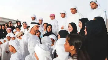  ?? WAM/Gulf News archives ?? Shaikh Mohammad Bin Zayed Al Nahyan talks to martyrs’ children who have excelled in school as their family members and teachers look on.