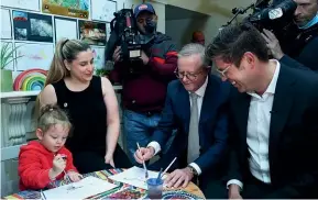  ?? GETTY IMAGES ?? Labor leader Anthony Albanese paints during a campaign visit to the Goodstart Early Learning Centre in West Ryde, Sydney, yesterday. Albanese has promised that if elected, his government will spend more than A$5 billion on reducing the cost of childcare.