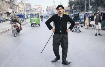  ?? PHOTO: REUTERS ?? Make ’em laugh . . . Usman Khan (29), dressed as Charlie Chaplin, performs along the street in Peshawar, Pakistan.