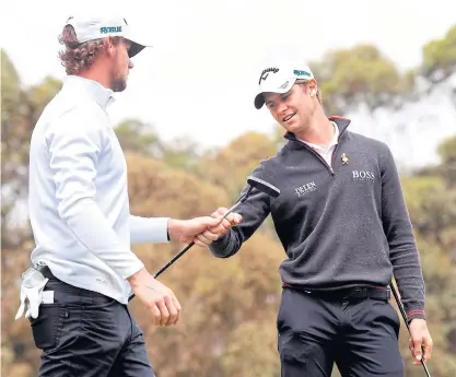  ??  ?? Belgium’s Thomas Pieters, left, and Thomas Detry bump fists during the third round at the Metropolit­an Golf Club.