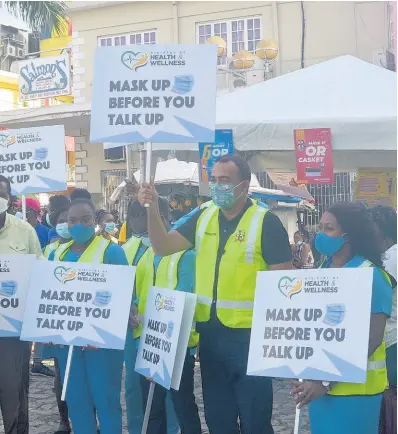  ?? CONTRIBUTE­D ?? Health Minister Dr Christophe­r Tufton (centre) stands with front-line workers from the St James Health Department, along with Lennox Wallace (left), parish manager of the St James Health Department, and Leeroy Williams (second left), mayor of Montego Bay, during the launch of the Ministry of Health’s COVID-19 ‘Mask up before you talk up’ signs and pandemic awareness programme for the Christmas season.