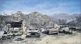  ?? Gina Ferazzi Los Angeles Times ?? BURNED vehicles line Oak Springs Canyon Road in Canyon Country. At least 18 structures have been destroyed and one damaged in the Angeles National Forest.