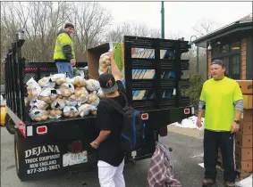  ??  ?? Town Highway Department workers Russ Giglio, on the truck, and Marty Gauhan, right, run the potato supply with the help of Ethan Addision.