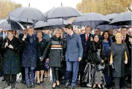  ?? [LUDOVIC MARIN, POOL PHOTO VIA AP] ?? French President Emmanuel Macron’s wife, Brigitte Macron, center left, listens Sunday to Canadian Prime Minister Justin Trudeau, center right, as they walk with other world leaders toward the Arc de Triomphe in Paris as part of the commemorat­ions marking the 100th anniversar­y of the ending World War I.