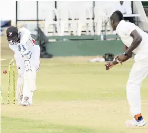  ?? ALLEN/PHOTOGRAPH­ER IAN ?? Trinidad and Tobago Red Force captain Dinesh Ramdin (left) is bowled by Rovman Powell of the Jamaica Scorpions on the first day of the WICB Profession­al Cricket League Four-day match at Sabina Park yesterday.