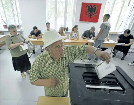  ?? HEKTOR PUSTINA/THE ASSOCIATED PRESS ?? An Albanian man casts his ballot at a polling station in Tirana, on Sunday. Albanians were voting in a general election that follows a landmark agreement between the country’s two biggest political parties to look past their bitter difference­s and back...