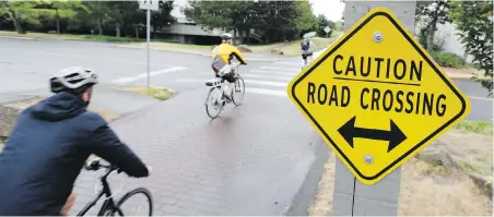  ?? TIMES COLONIST FILE ?? Helmets aren’t mandatory for cyclists on the Galloping Goose Regional Trail but they are on public roads, which creates a conundrum at road crossings, Steve Wallace writes.