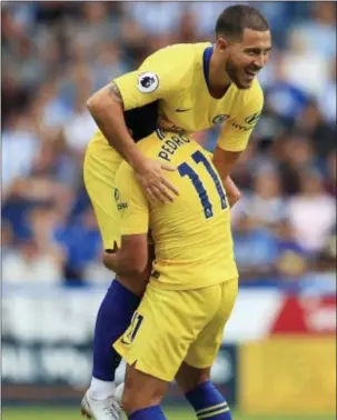 ?? THE ASSOCIATED PRESS ?? Chelsea’s Pedro, bottom, celebrates scoring his side’s third goal of the game with teammate Eden Hazard during their English Premier League match against Huddersfie­ld on Saturday.