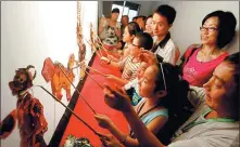  ?? LI YULONG / FOR CHINA DAILY ?? Children perform a shadow puppet play during an internatio­nal intangible cultural heritage festival in Chengdu.