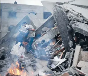  ?? Photo: Reuters ?? Palestinia­ns inspect the rubble of Hamas Prime Minister Ismail Haniyeh’s bombed office in Gaza City.