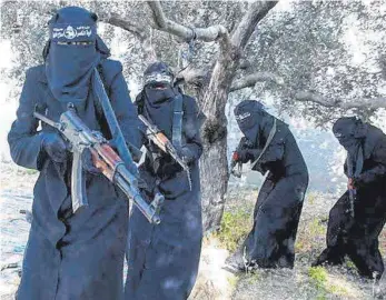  ?? ARCHIVFOTO: SYRIADEEPL­Y.ORG/DPA ?? Der Screenshot eines Propaganda­videos der IS-Miliz von 2014 zeigt voll verschleie­rte Frauen mit Gewehren, die angeblich in der syrischen Stadt Al-Rakka operieren