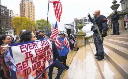  ?? MATTHEW DAE SMITH AP ?? Protesters rally to denounce Gov. Gretchen Whitmer’s stay-home order and business restrictio­ns due to COVID-19, at the state Capitol in Lansing, Mich., in April. Armed men charged in a plot against Whitmer are said to have attended such rallies.