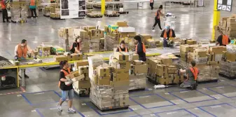  ?? Erika Schultz / Seattle Times ?? Employees work at the Kent, Wash., sorting center of Amazon, one of the FANG companies — Facebook, Amazon, Netflix and Google ( now Alphabet) — whose stock has plunged in 2016.