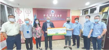  ??  ?? Goh (fourth from left) handing over his personal donation of RM10,000 to Yeh, witnessed by Kian Kok Middle School board members.