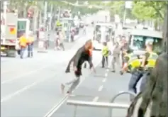  ??  ?? This handout video grab via the Instagram account of Chris Newport shows a man fighting with policemen in downtown Melbourne after he stabbed a number of people.