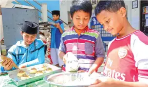  ?? ALFIAN RIZAL/JAWA POS ?? PRODUKSI ROKER: Para penghuni Panti Asuhan Muhammadiy­ah KH Mas Mansyur membuat roti kering. Hasil penjualan digunakan untuk membiayai aktivitas panti.