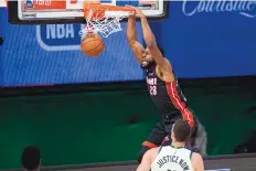  ?? MARK J. TERRILL/ASSOCIATED PRESS ?? Miami’s Andre Iguodala (28) dunks in front of Milwaukee’s Brook Lopez during the Heat’s series-clinching victory over the Bucks on Tuesday night.