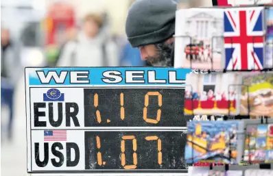  ?? AP ?? People walk past a sign that shows the exchange rate at a bureau de change in London on Tuesday, September 27, 2022.