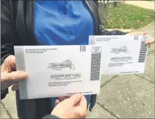  ?? PETE BANNAN - MEDIANEWS GROUP ?? Robert and Melissa Bair of Media hold their absentee ballots which they dropped off at Delaware County Governemen­t Center Tuesday.