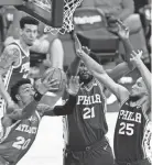  ?? MATT SLOCUM/AP ?? Atlanta Hawks' John Collins goes up for a shot against Philadelph­ia's Joel Embiid (21) and Ben Simmons on Tuesday.