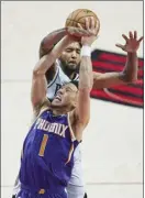  ?? AP photo ?? Devin Booker of the Suns is fouled by the Trail Blazers’ Derrick Jones Jr. during the first half of Phoenix’s 127-121 win over Portland on Thursday.