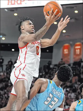  ?? The Associated Press Kevin M. Cox ?? Houston guard Marcus Sasser soars to the basket against Kent State forward Miryne Thomas in the second half of the Cougars’ 49-44 victory Saturday at Fertitta Center.