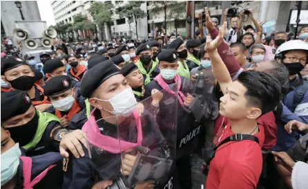  ?? | EPA ?? A PROTESTER confronts police officers during a rally against the state of emergency at Ratchapras­ong district in Bangkok, yesterday.