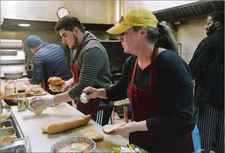  ?? DANA JENSEN/THE DAY ?? Owner Monica Rossi, right, of Monica’s State Street Diner, and Ahmed Gusainov, left, of Wings ‘n’ Pies, work on lunch orders in the kitchen on the first day of Monica’s @ Wings ’n’ Pies, Wednesday. The Monica’s State Street Diner located across from Wings ’n’ Pies on State Street in New London has moved in with Wings ’n’ Pies and the businesses have joined together.