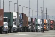  ?? Ben Margot / Associated Press ?? Trucks wait to unload shipping containers at the Port of Oakland. Overseas demand has weakened.