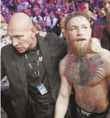  ?? AP PHOTO ?? POST-BOUT BRAWL: Conor McGregor is escorted from the cage area after losing his lightweigh­t battle.