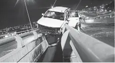  ??  ?? Percance. El vehículo a punto estuvo de caer de lo alto del puente.