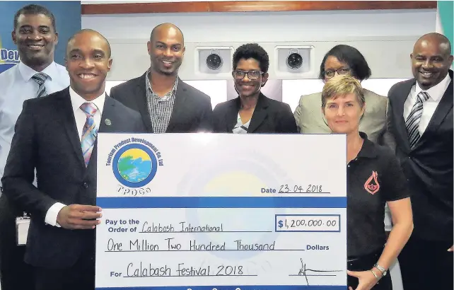  ??  ?? Executive Director of Tourism Product Developmen­t Company Limited (TPDCo), Dr Andrew Spencer (left foreground) presents a $1.2-million contributi­on to coorganize­r of the Calabash festival, (right) Justine Henzell. They are joined by TPDCo staff members...
