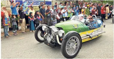  ??  ?? On the road again: Sultan Ibrahim driving the Morgan as he is accompanie­d by Raja Zarith Sofiah at Felda Air Tawar Tiga in Kota Tinggi, Johor.