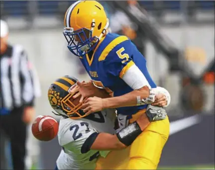  ?? DAVID TURBEN — THE NEWS-HERALD ?? Kirtland’s Alex Weaver forces a fumble on Marion Local QB Nathan Bruns on Dec. 2 in the Division VI state championsh­ip game in Canton.