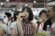  ?? THE ASSOCIATED PRESS ?? A woman drinks beer Thursday at the 2018 Craft Beer of China Exhibition in Shanghai. Hundreds of craft beer enthusiast­s, investors and brewers are attending an exhibition in Shanghai dedicated to expanding the palette of Chinese consumers and promoting...