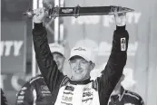  ?? MARK HUMPHREY AP ?? AJ Allmending­er holds up the winner’s sword after a NASCAR Xfinity Series victory at Bristol in Tennessee.
