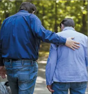  ?? BRYNN ANDERSON — THE ASSOCIATED PRESS ?? Rick Bragg, 58, left, and Margaret Bragg, 81, right, walk in their driveway on Wednesday in Jacksonvil­le, Ala.