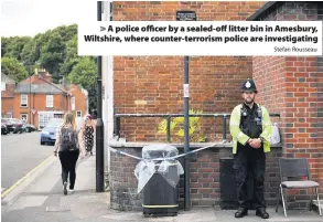  ?? Stefan Rousseau ?? > A police officer by a sealed-off litter bin in Amesbury, Wiltshire, where counter-terrorism police are investigat­ing