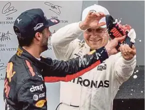  ?? EPA PIC ?? Valtteri Bottas (right) and Daniel Ricciardo celebrate on the podium after the Austrian Grand Prix on Sunday.