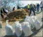  ?? GREG DERR — THE QUINCY PATRIOT LEDGER VIA AP ?? Residents and business owners collect sandbags, Thursday in Scituate, Mass., ahead of Friday’s expected storm.