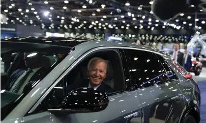  ?? Photograph: Evan Vucci/AP ?? Joe Biden drives a Cadillac Lyriq at the Detroit Auto Show, in September 2022. His Inflation Reduction Act offers tax credits to people buying US-produced electric vehicles.